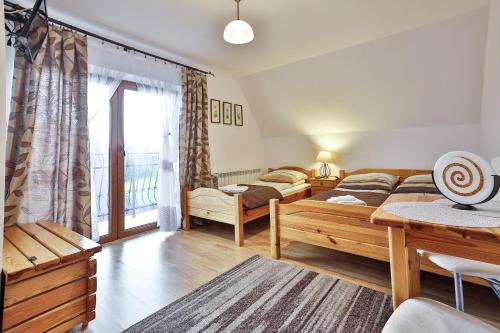 ein Wohnzimmer mit einem Bett und einem großen Fenster in der Unterkunft Kwatery u Jacka in Groń
