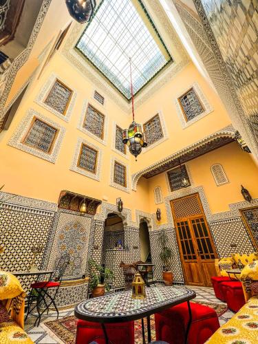 a room with a table and chairs and a ceiling at Riad Diamant De Fes in Fès