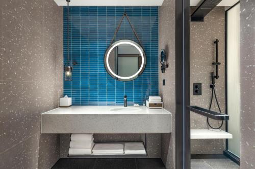 a bathroom with a sink and a mirror at Four Points by Sheraton Urumqi in Ürümqi