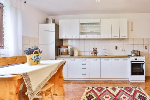 a kitchen with white cabinets and a table at Kwatery u Jacka in Groń