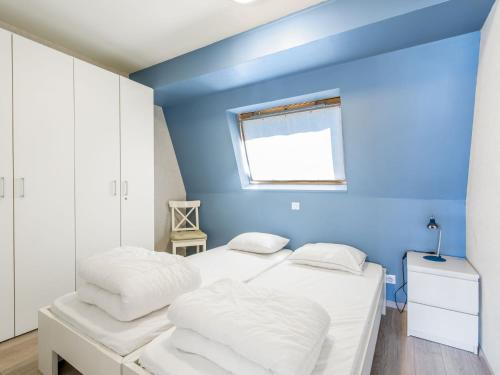 - 2 lits dans une chambre avec un mur bleu dans l'établissement Nouvella 2 bedrooms on floor 3, à Blankenberge