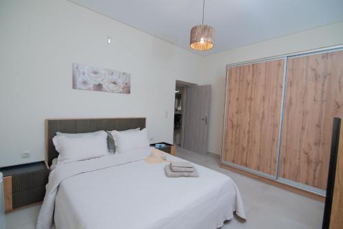 a bedroom with a large white bed with towels on it at Silva Luxury House in Mires (South Crete) in Moírai