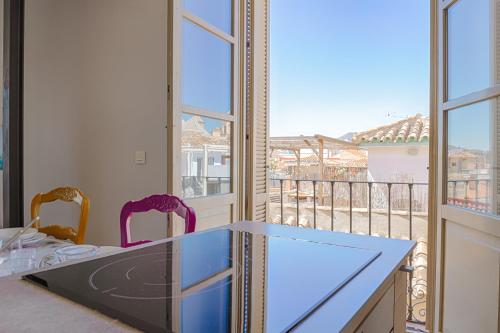 a kitchen with a table and a view of a balcony at C20 - Adorable Apartment in the Center with Sun Terrace in Málaga