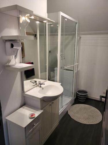 une salle de bain blanche avec un lavabo et une douche dans l'établissement Du bon temps, à Bôo-Silhen