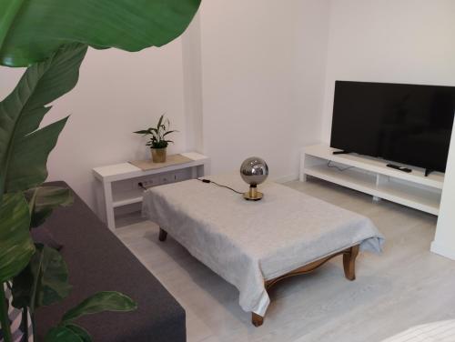 ein Wohnzimmer mit einem Sofa, einem Tisch und einem TV in der Unterkunft Manoir de la Guignardiere : Thé ou café ? in Chavagne