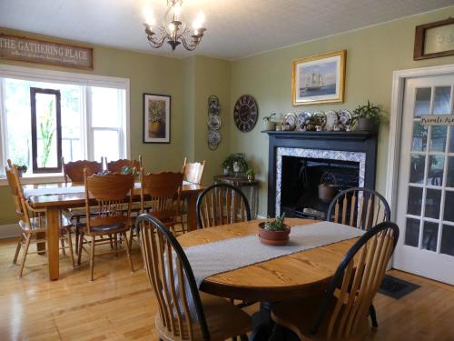 uma sala de jantar com uma mesa e cadeiras e uma lareira em Willow House Inn B&B em Pictou