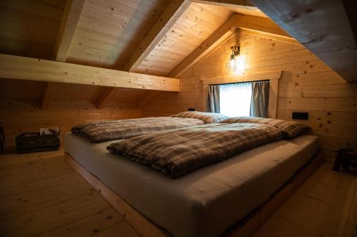 una camera con 2 letti in una cabina di legno di Ferienhäuser Koralpe unicorn village a Wolfsberg