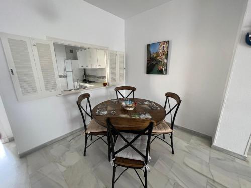 a dining room with a table and chairs and a kitchen at CASA RAUSER in Chipiona
