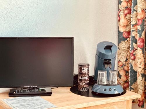 a desk with a computer monitor and a coffee maker at Birnbom Warnemünde in Warnemünde