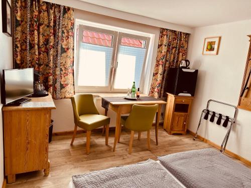 a room with a table and chairs and a window at Birnbom Warnemünde in Warnemünde