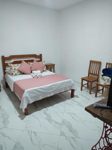 a bedroom with a bed and two chairs and a laptop at Hotel Lumiar in Lumiar