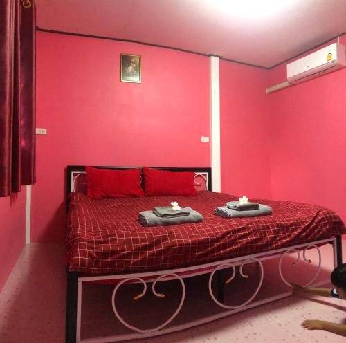 a red bedroom with a bed with two candles on it at ต้นกล้า รีสอร์ท 
