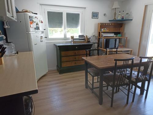 La cuisine est équipée d'une table, de chaises et d'un réfrigérateur. dans l'établissement Suite avec billard et jacuzzi, à Bergerac