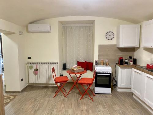 a kitchen with a table and red chairs in a room at MareLuna Guest House in Naples