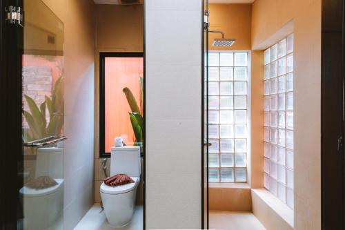 a bathroom with a toilet and a window at Layantara Villas in Layan Beach