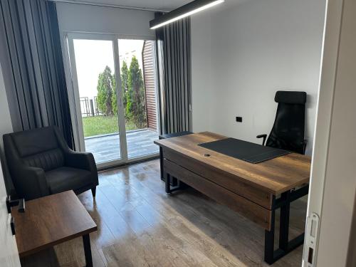 a desk and a chair in a room with a window at Luxury Apartment with Garden right by sea in Mudanya