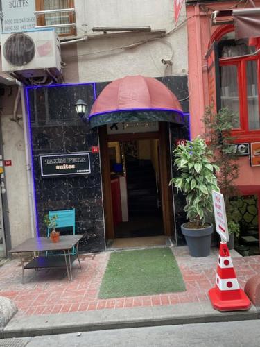 an entrance to a building with a red and blue umbrella at taksim pera suıtes in Istanbul