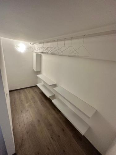 une pièce vide avec des étagères blanches sur le mur dans l'établissement Appartamento Marco Simone, à Marco Simone