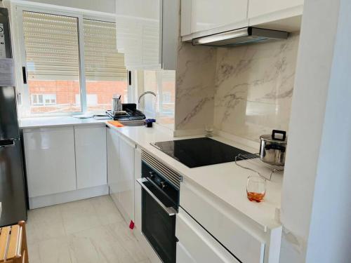 cocina blanca con fregadero y fogones en Apartamento en Santander, en Santander