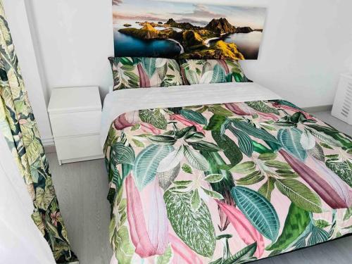 1 dormitorio con 1 cama con colcha de flores en Apartamento en Santander, en Santander