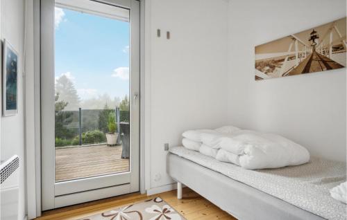 Dieses weiße Zimmer verfügt über eine Tür, die auf einen Balkon führt. in der Unterkunft 3 Bedroom Pet Friendly Home In Ebeltoft in Ebeltoft