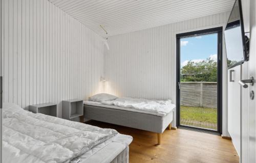ヒュールスミンネにあるAmazing Home In Juelsminde With 4 Bedrooms And Wifiのベッドルーム1室(ベッド2台、大きな窓付)