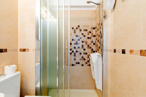 a bathroom with a shower with a glass door at Las Americas Acapulco 4 Costa Adeje in Playa Fañabe