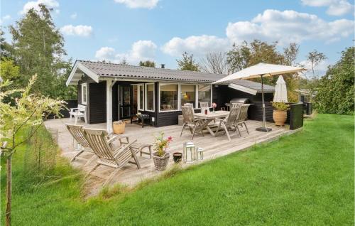a wooden deck with a table and chairs and an umbrella at 3 Bedroom Stunning Home In Skibby in Skibby