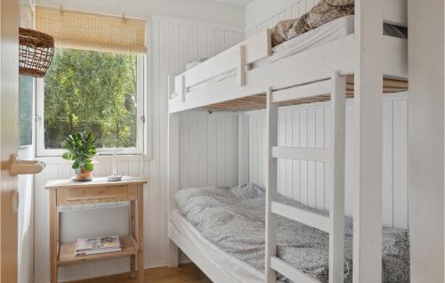 a white bunk bed in a small room with a window at 3 Bedroom Amazing Home In Bog By in Bogø By