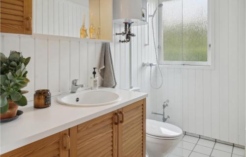 łazienka z umywalką, toaletą i oknem w obiekcie 3 Bedroom Amazing Home In Bog By w mieście Bogø By