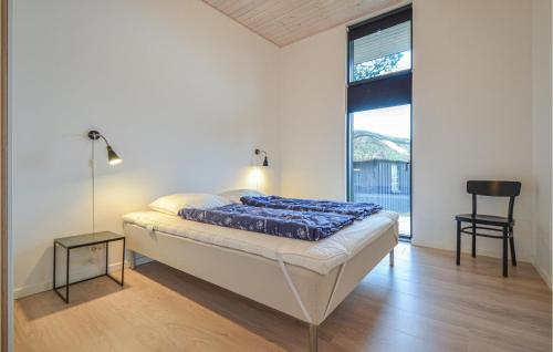 エーベルトフトにあるStunning Home In Ebeltoft With 4 Bedrooms And Wifiのベッドルーム1室(ベッド1台、椅子、窓付)