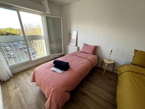 - une chambre avec un lit doté d'une couverture rouge et d'une fenêtre dans l'établissement Hana Home Spacieux t4 Calme Parking gratuit sur place, à Mantes-la-Jolie