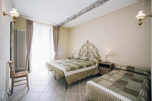a bedroom with two beds and a chair at Le Dimore di Diana in Venaria Reale