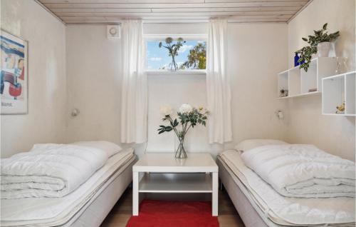 - 2 lits dans une chambre avec un vase de fleurs sur une table dans l'établissement 3 Bedroom Beautiful Home In Vordingborg, à Vordingborg