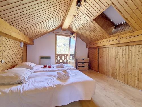 a bedroom with a large white bed in a wooden ceiling at Chalet Méribel, 5 pièces, 8 personnes - FR-1-688-57 in Méribel