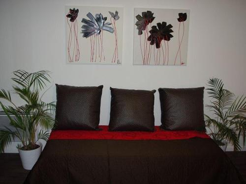 um quarto com uma cama com almofadas e dois quadros em Studio Brides-les-Bains, 1 pièce, 4 personnes - FR-1-512-217 em Brides-les-Bains