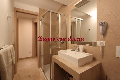 La salle de bains est pourvue d'un lavabo et d'une douche. dans l'établissement Residence Alpen Park, à Molveno