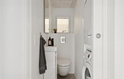 een badkamer met een toilet, een wasmachine en een droger bij Awesome Home In Tranekr With House Sea View in Tranekær