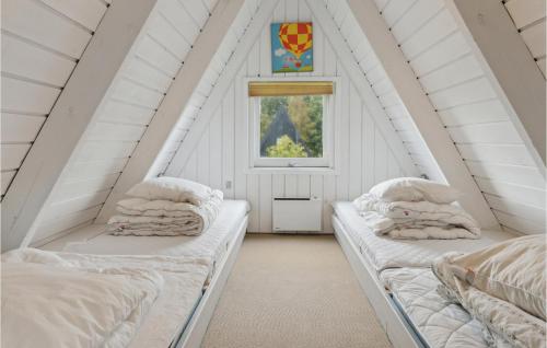 two beds in a attic room with a window at Gorgeous Home In Fars With Kitchen in Farsø