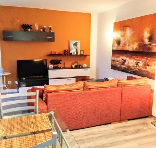 プラヤ・パライソにあるAdeje300, Playa Paraísoのリビングルーム(オレンジ色の壁、ソファ付)