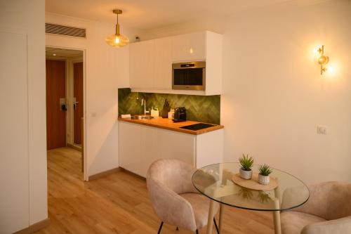 a kitchen with a glass table and two chairs at Sweet'Issy - Balcon - Parking - Climatisation - WIFI - MyBestLoc in Issy-les-Moulineaux