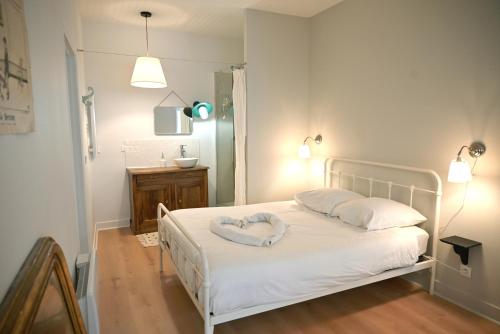 ブリウドにあるLa Brocante - Meilleurhote-Brioudeのベッドルーム1室(ハートピロー付きの白いベッド1台付)