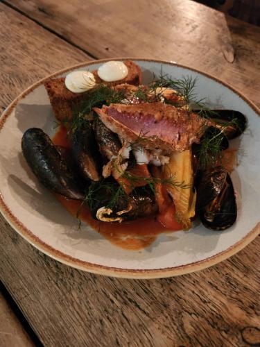 a plate of food with meat and vegetables on a table at Kew Gardens Hotel in Kew