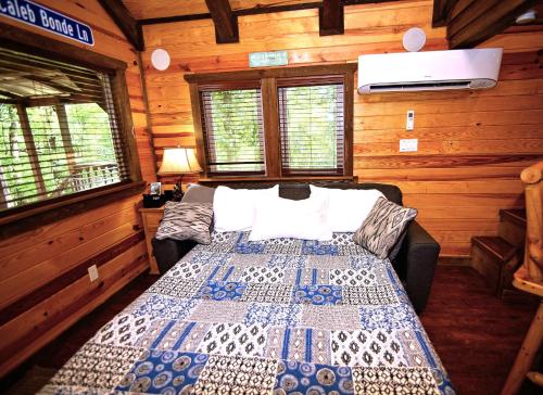 a bedroom with a bed in a log cabin at The Codex - Parker Creek Bend Cabins in Murfreesboro