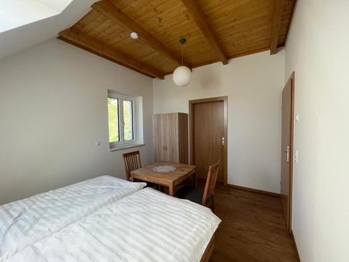 a bedroom with a bed and a wooden table at Ferienhaus am Hof Zotter in Riegersburg
