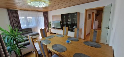 a living room with a wooden table and a dining room at TOP 3-Zimmerwohnung nähe Kurpark in Bad Rappenau