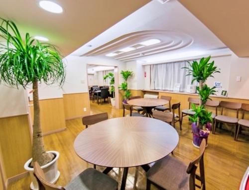 um escritório com mesas e cadeiras e vasos de plantas em Hotel Yuni -Comfortable stay Star-Club iD em Tóquio