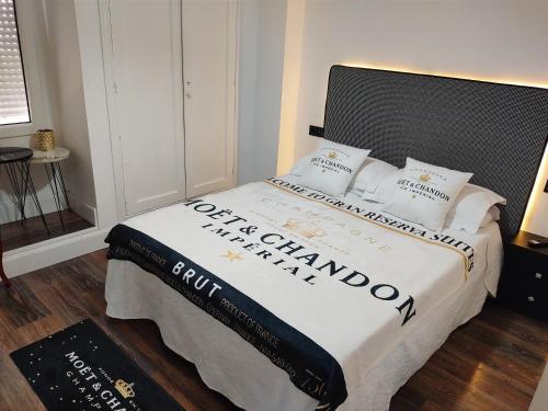 1 dormitorio con 1 cama con sábanas y almohadas blancas en Gran Reserva Suites centro alojamiento entero, en Logroño
