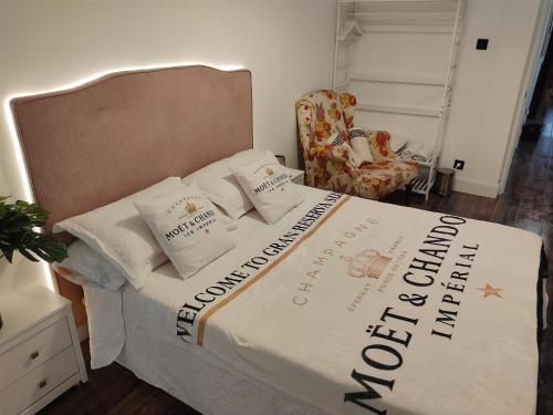 1 dormitorio con 1 cama con edredón y silla en Gran Reserva Suites centro alojamiento entero, en Logroño