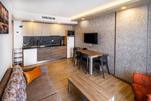 eine Küche und ein Wohnzimmer mit einem Tisch und einem Sofa in der Unterkunft Golden World Suite Hotel in Antalya